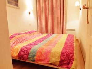 1 dormitorio con 1 cama con un edredón colorido en Val de Jade, Le Marmotton, T2, centre Luchon, wifi, casier à skis, 5 personnes en Luchon