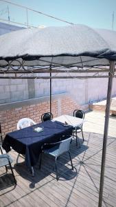 dos mesas y sillas bajo una sombrilla en una cubierta en Económicas y Cómodas Habitaciones Privadas cerca de Playa en Arica