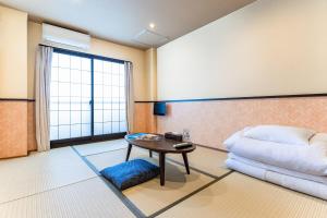 Postel nebo postele na pokoji v ubytování Tabist Sparkling Dolphins Inn Kyoto
