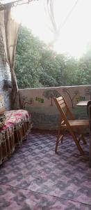 une chambre avec une table et un banc à côté d'un lit dans l'établissement NUBA ONe, à Assouan