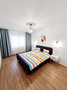a bedroom with a bed with a colorful blanket on it at Eden Apartment in Cluj-Napoca