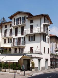 a large white building with balconies on a street at Hotel Avogadro in San Pellegrino Terme