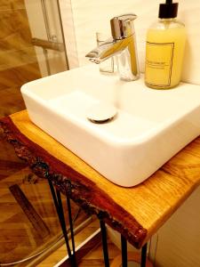 a white sink sitting on top of a wooden table at Eden Apartment in Cluj-Napoca