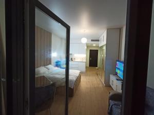 a bedroom with a bed and a tv and a mirror at Solo Visit Apartments 1709 B in Batumi +43 photos