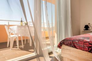 a bedroom with a bed and a table and a balcony at Apartment Alja, Sara i Nevio jacuzzi in Dugi Rat