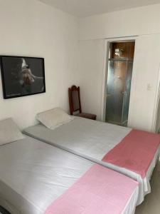 1 dormitorio con 2 camas y TV en la pared en apto na quadra do mar, en Recife
