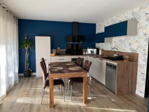 a kitchen with a wooden table and a blue wall at Entre terre et mer à cassis in Cassis