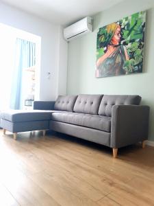 a couch in a living room with a painting on the wall at Eden Apartment in Cluj-Napoca