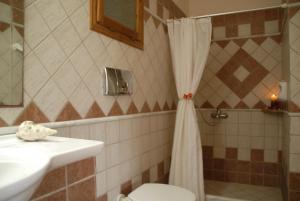 a bathroom with a toilet and a sink and a shower at Eva Studios in Kassiopi