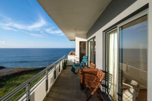 uma varanda com cadeiras e vista para o oceano em Mar Grande Apartment na Ribeira Grande