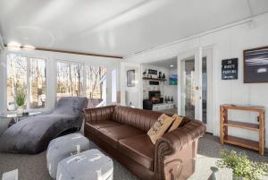 ein Wohnzimmer mit einem braunen Ledersofa und einem Tisch in der Unterkunft Lakefront Getaway by Michigan Waterfront Luxury Properties in Rothbury