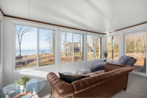 ein Wohnzimmer mit einem Ledersofa und einem Glastisch in der Unterkunft Lakefront Getaway by Michigan Waterfront Luxury Properties in Rothbury