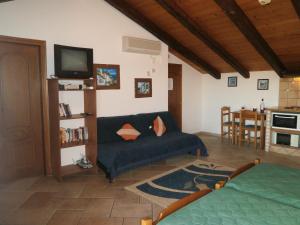 a living room with a couch and a tv at Eva Studios in Kassiopi