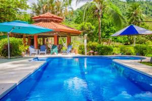 uma piscina com um gazebo e uma casa em Los Malinches em Jacó