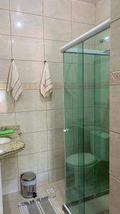 y baño con ducha y puerta de cristal. en Suites Arraial do Cabo, en Arraial do Cabo