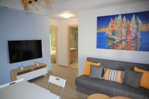 a living room with a couch and a tv at La Casita a brand new apartment in the center in Argostoli