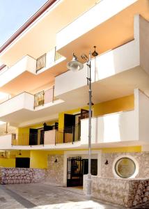 a building with balconies and a street light at Le Tartarughe Aparthotel in Letojanni