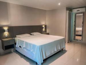 a bedroom with a large bed and a window at Long Beach in Canoa Quebrada