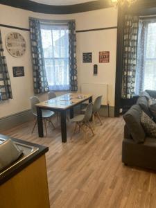 a living room with a dining room table and chairs at Lovely 2 Bed Sea Front apartment @ 10A George Street in Ryde