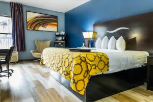 a hotel room with a bed with a yellow and white blanket at Baymont by Wyndham London KY in London