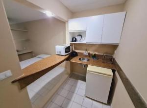 una pequeña cocina con fregadero y microondas en VICTORY BUSINESS FLAT TAMBAU, en João Pessoa