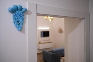 ein Zimmer mit einem blauen Herz, das an einer Wand hängt in der Unterkunft FLOWER SUITE B&B in Syrakus