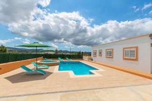 a swimming pool with lounge chairs and an umbrella at Can Pep De Sa Rota in San Antonio