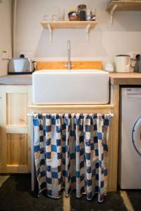 a kitchen with a sink and a washing machine at Glynn's Charming cottage in the Burren in Fanore