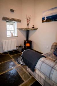 ein Schlafzimmer mit einem Bett und einem Kamin in einem Zimmer in der Unterkunft Glynn's Charming cottage in the Burren in Fanore