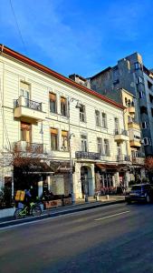 una persona montando una bicicleta delante de un edificio en Ultracentral Cozy Apartment on Calea Victoriei with Amazing View, en Bucarest
