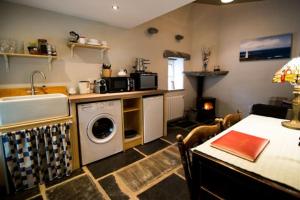 een keuken met een wasmachine en droger en een tafel bij Glynn's Charming cottage in the Burren in Fanore