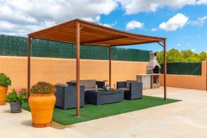 a pavilion with chairs and a grill in a yard at Can Pep De Sa Rota in San Antonio