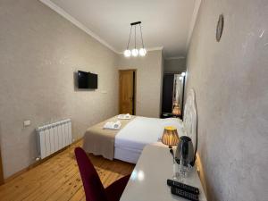Habitación de hotel con cama, mesa y sillas en Guest House Lusi, en Tiflis