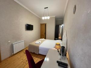 a hotel room with a bed and a table and chairs at Guest House Lusi in Tbilisi City