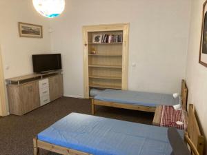 een kleine kamer met 2 bedden en een televisie bij Apartment Žižkova 159, Terezín in Terezín