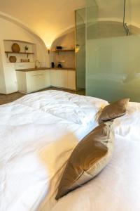 een groot bed in een kamer met een glazen wand bij Penzion Fara pod Milešovkou in Velemín
