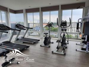 een fitnessruimte met verschillende loopbanden in een kamer met ramen bij Fluffy bed and seaview @Bangsaen in Ban Bang Saen (1)