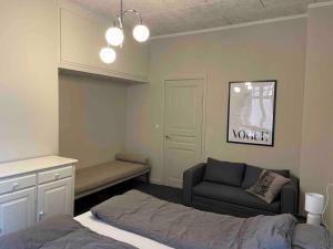 a bedroom with a bed and a couch and a chair at Cozy 4-Bedroom Apartment Aalborg in Aalborg