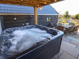 a hot tub with snow in it on a patio at Foxes Den in Scarborough