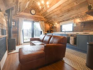 a living room with a brown couch in a kitchen at Foxes Den in Scarborough