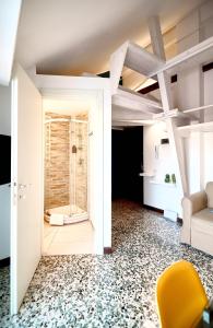 a living room with a yellow chair and a shower at RELSTAY - Washington Street in Milan