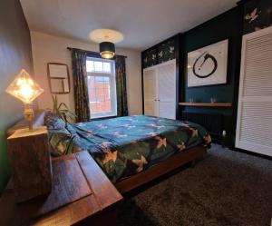 a bedroom with a bed and a table and a lamp at No.2 Boutique Art Townhouse  in Lincolnshire