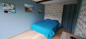 een slaapkamer met een blauw bed in een kamer bij Ty Coeur Breizh in Saint-Aignan