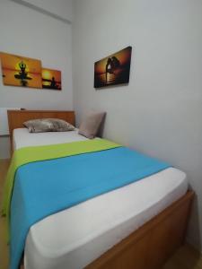 two beds in a bedroom with two pictures on the wall at Feeling at home in İstanbul Center 5 Minutes walk to The Ataköy Metro Station & Metrobus in Istanbul