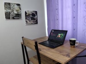 a laptop on a wooden desk with a cup of coffee at Feeling at home in İstanbul Center 5 Minutes walk to The Ataköy Metro Station & Metrobus in Istanbul