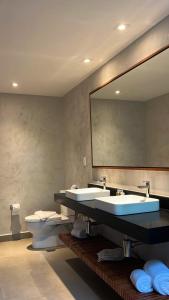 uma casa de banho com 2 lavatórios, um espelho e um WC em Pousada Ecológica Akanã em Fernando de Noronha