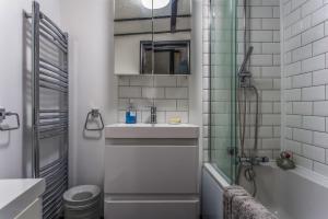 y baño pequeño con lavabo y ducha. en Modern living, Charming Old Town Cottage en Hastings