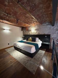 a bedroom with a bed and a brick wall at Hotel Boutique Rayón 50 in Morelia