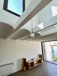 a living room with a skylight and a table at loft en el centro in Vilanova i la Geltrú