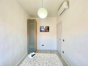 korytarz z pokojem z telewizorem na ścianie w obiekcie Piramides 1 Apartment w Madrycie